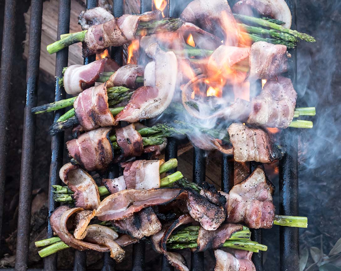 Cooking bacon appetizers over an open fire